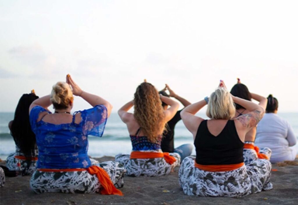 Women sitting at the beach in meditating